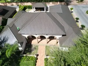 Aerial view of a brown standing seam metal roof above an arched front entry