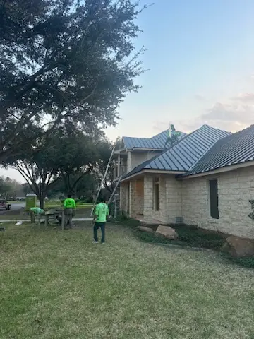 Marva Roofing crew working on a metal roof on a stone home