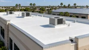 White commercial TPO roof with HVAC units and a neighboring standing-seam metal roof