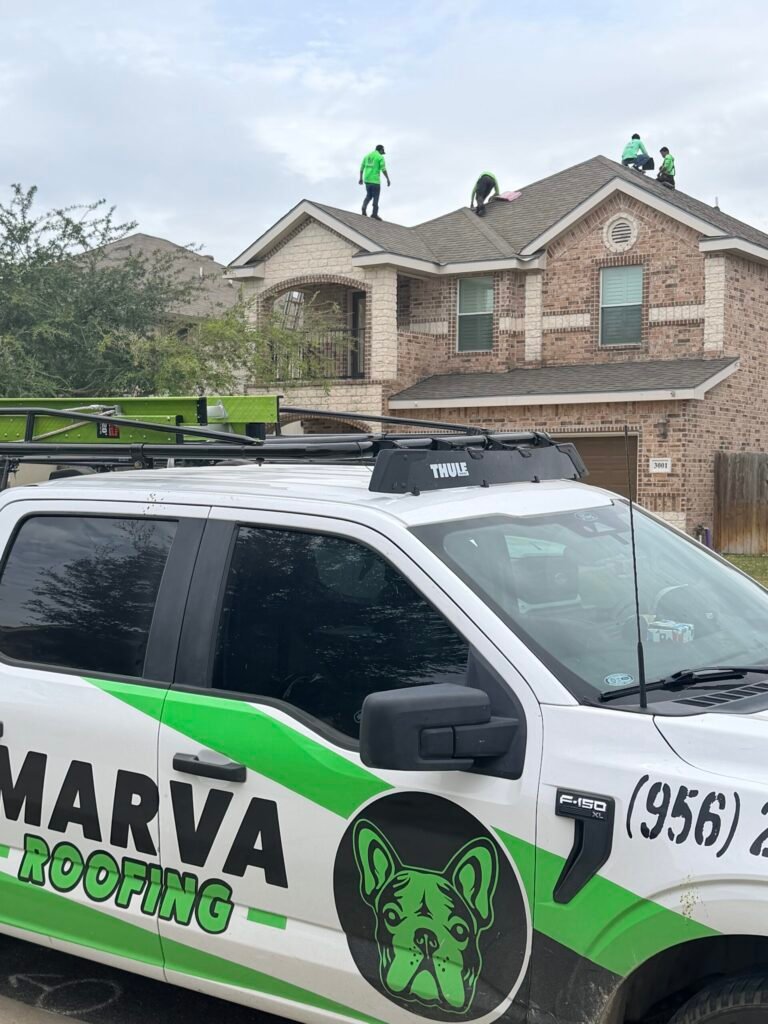 Marva Roofing truck in front of a two-story home with crew members working on the shingle roof.